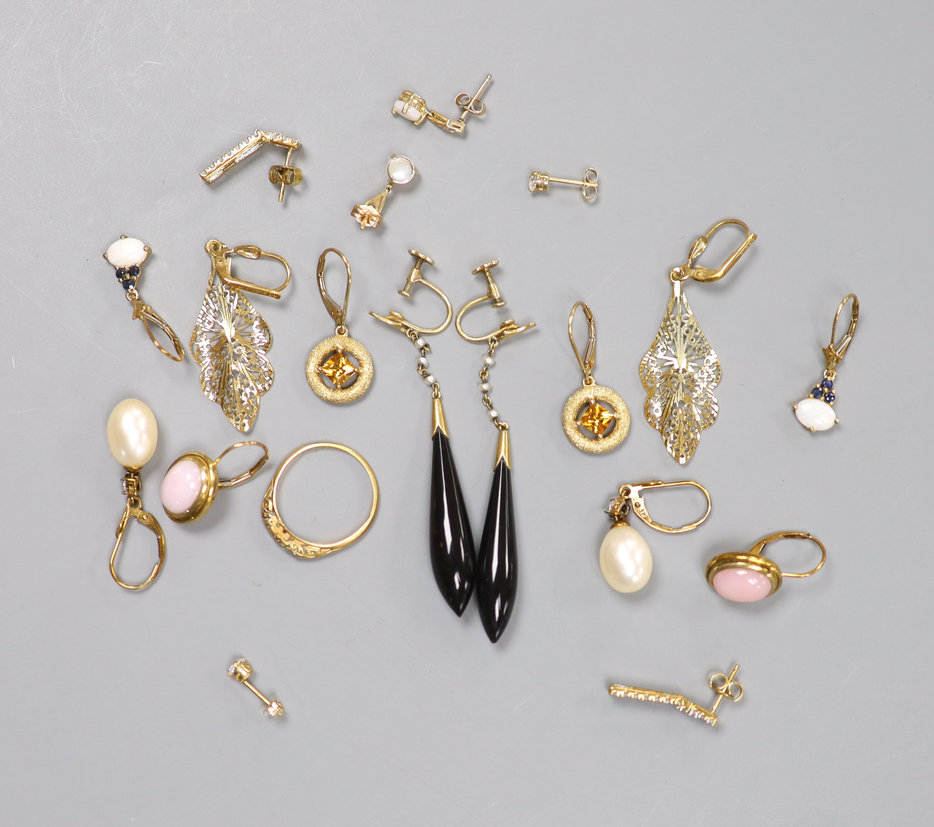 Seven pairs of hallmarked gold earrings, variously set, a single 14K marked stud earring, a pair of drop earrings and a yellow metal ring